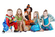 Children in carnival costumes sit on chest and on floor