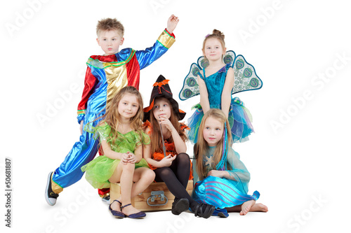 Photo: Children in carnival costumes sit on chest and stand beside Children in carnival costumes sit on chest and stand beside