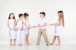 Four disputing little girls and one boy draw over rope