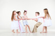 Photo: Five happy little children in white clothes draw over pink rope. Five happy little children in white clothes draw over pink rope.