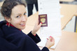 Woman shows passport and voting paper at elections