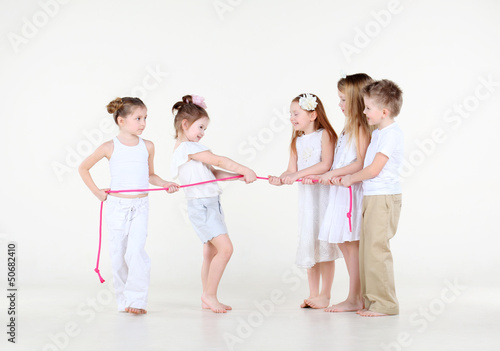 Photo: Five cute little children in white clothes draw over pink rope. Five cute little children in white clothes draw over pink rope.