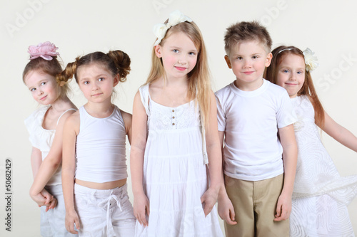 Photo: Five smiling children in white clothes stand and look at camera. Five smiling children in white clothes stand and look at camera.