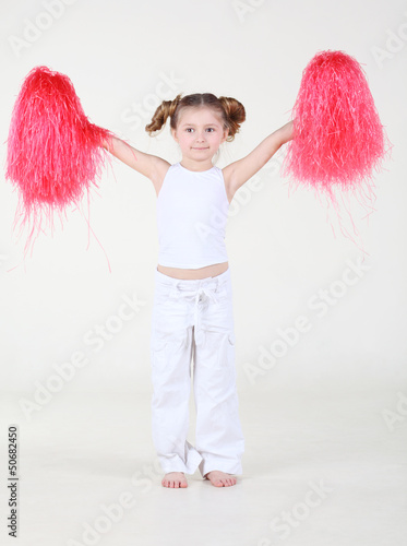Photo: Little happy girl with funny hairdo holds pompons Little happy girl with funny hairdo holds pompons