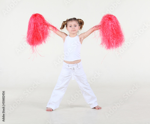 Photo: Little barefoot girl with funny hairdo holds pompon Little barefoot girl with funny hairdo holds pompon