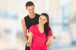 Woman with her personal trainer exercising with weights in gym