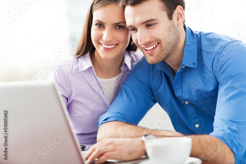 Photo: Young couple using laptop Young couple using laptop