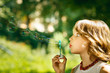 Portrait of funny lovely girl blowing soap bubbles outdoor