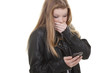 Jugendliche schaut erschrocken auf ihr Mobil Telefon