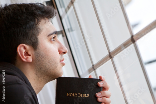 Photo: Man Holding Bible Looking Out Window Man Holding Bible Looking Out Window