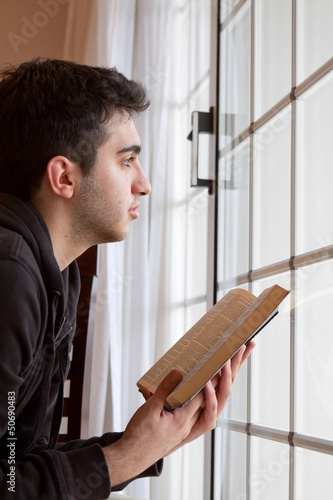 Photo: Man Holding Bible Looking Out Window Man Holding Bible Looking Out Window