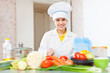  cook woman  in uniform cutting vegetables