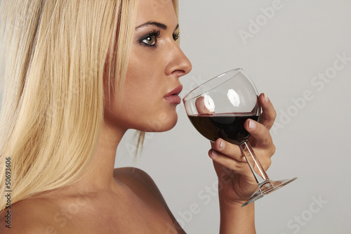 Photo: beautiful blond woman tasting red wine beautiful blond woman tasting red wine