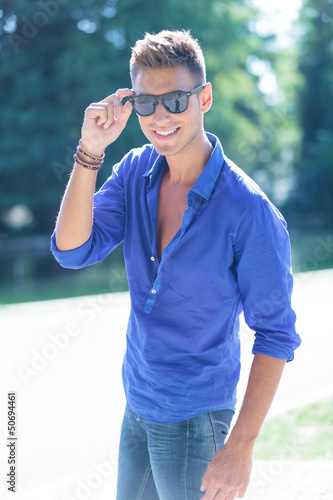 Photo: man holding his glasses in nature man holding his glasses in nature