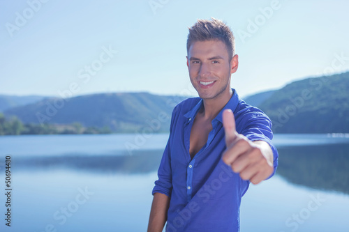 Photo: man shows ok by the lake man shows ok by the lake