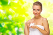 Young girl with body cream on floral background