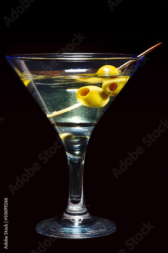 Photo: Glass of Martini with olives on black Glass of Martini with olives on black
