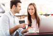 Young business people using laptop at cafe