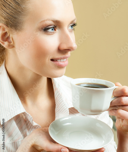 Photo: Young woman drinking coffee or tea, at home Young woman drinking coffee or tea, at home