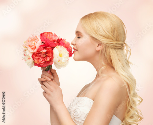 Photo: woman smelling bouquet of flowers woman smelling bouquet of flowers