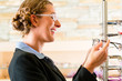 Junge Frau beim Optiker kauft Brille