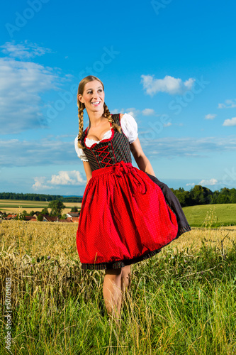 Photo: Junge Frau auf der Wiese und trägt Dirndl Junge Frau auf der Wiese und trägt Dirndl