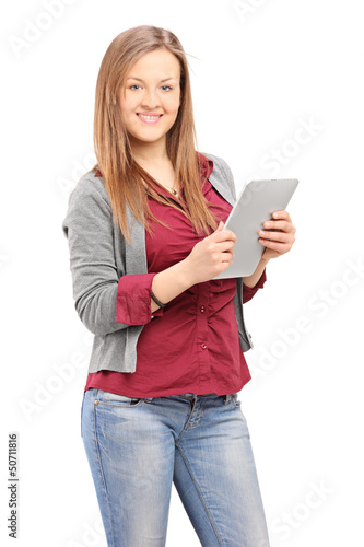 Photo: Young female holding a tablet and looking at camera Young female holding a tablet and looking at camera