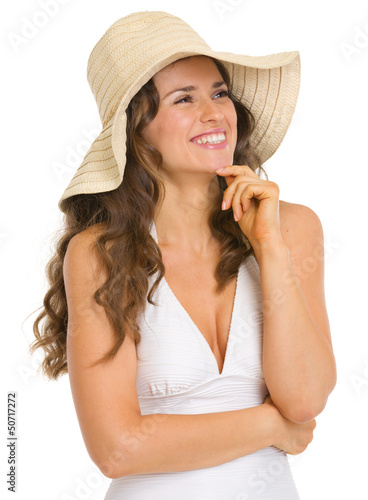 Photo: Happy young woman in swimsuit and hat looking on copy space Happy young woman in swimsuit and hat looking on copy space