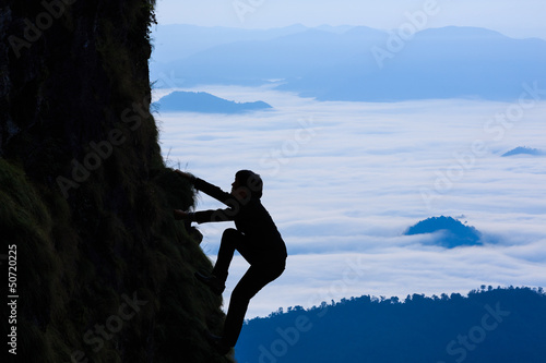Photo: Sihouette businessman climbs a mountain Sihouette businessman climbs a mountain