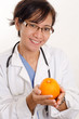 Photo: Attractive filipino asian nurse doctor holding orange Attractive filipino asian nurse doctor holding orange