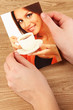 Photos in hands on wooden table