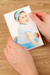 Photos in hands on wooden table