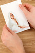 Photos in hands on wooden table