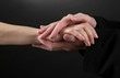 Priest holding woman hand, on black background