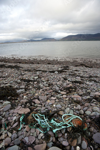 Photo: Rubbish on shore with water in background Rubbish on shore with water in background