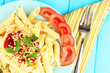 Rigatoni pasta dish with tomato sauce on blue wooden table