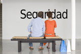 Photo: Rear view of couple reading Spanish text "seguridad" (security) and contemplating it Rear view of couple reading Spanish text "seguridad" (security) and contemplating it