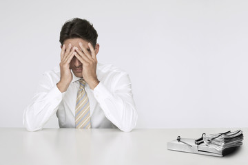 Photo: Worried businessman at table with wad of cash in mouse trap representing financial difficulties Worried businessman at table with wad of cash in mouse trap representing financial difficulties