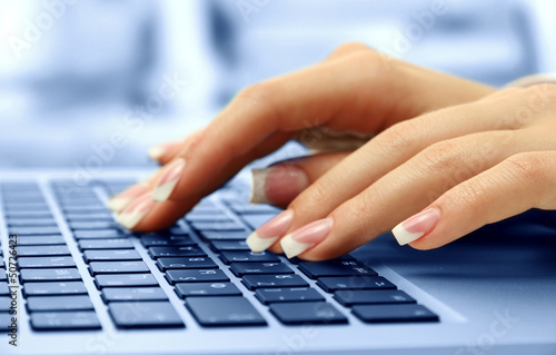 Photo: Female hands typing on laptot, close-up Female hands typing on laptot, close-up