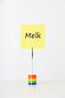Photo: Sticky notepaper with Dutch text "Melk" (milk) clipped to a multicolored card holder Sticky notepaper with Dutch text "Melk" (milk) clipped to a multicolored card holder