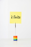 Photo: Sticky notepaper with Italian text meaning It's over clipped to a multicolored card holder Sticky notepaper with Italian text meaning It's over clipped to a multicolored card holder