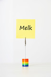 Photo: Sticky notepaper with Dutch text "Melk" (milk) clipped to a multicolored card holder Sticky notepaper with Dutch text "Melk" (milk) clipped to a multicolored card holder