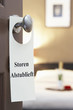 Photo: Sign with Dutch text "Storen Alstublieft" (please disturb) hanging on hotel room door Sign with Dutch text "Storen Alstublieft" (please disturb) hanging on hotel room door