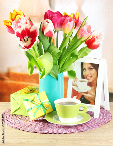 Photo: Beautiful tulips in bucket with gifts and cup of tea Beautiful tulips in bucket with gifts and cup of tea