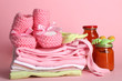 Pile of baby clothes on pink background