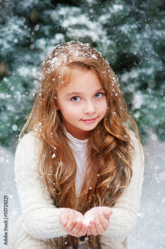 Photo: Beautiful liitle girl catches snowflakes Beautiful liitle girl catches snowflakes