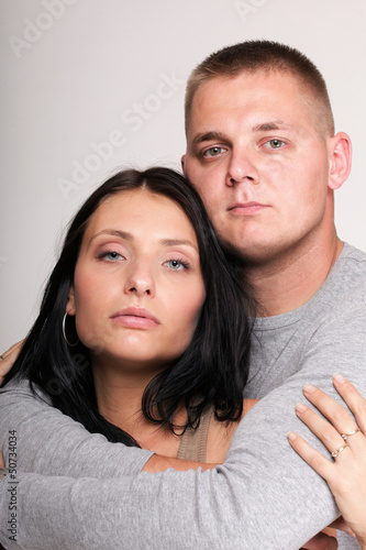 Photo: Beautiful pensive man woman stand near gray wal Beautiful pensive man woman stand near gray wal