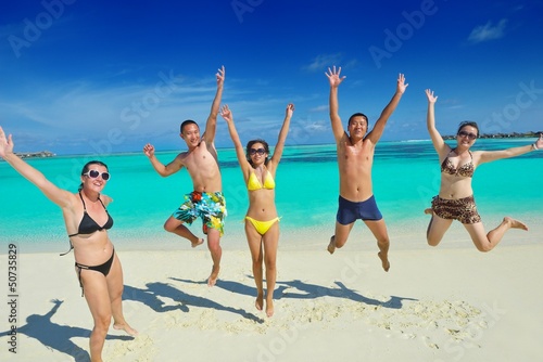 Photo: group of happy young people have fun on bach group of happy young people have fun on bach