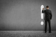 businessman painting exclamation mark on wall