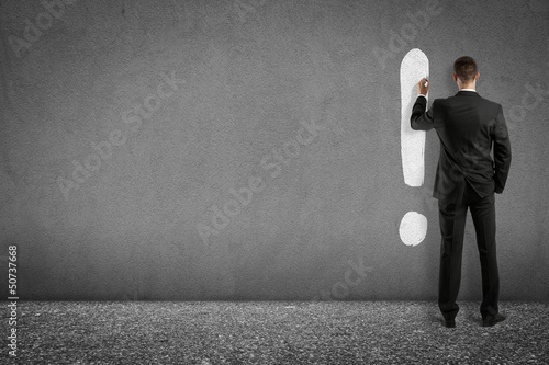 Photo: businessman painting exclamation mark on wall businessman painting exclamation mark on wall